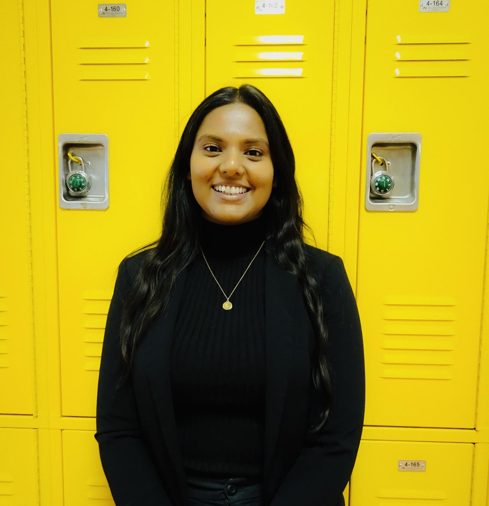 Shakana Jayson posed in school hallway beside yellow lockers