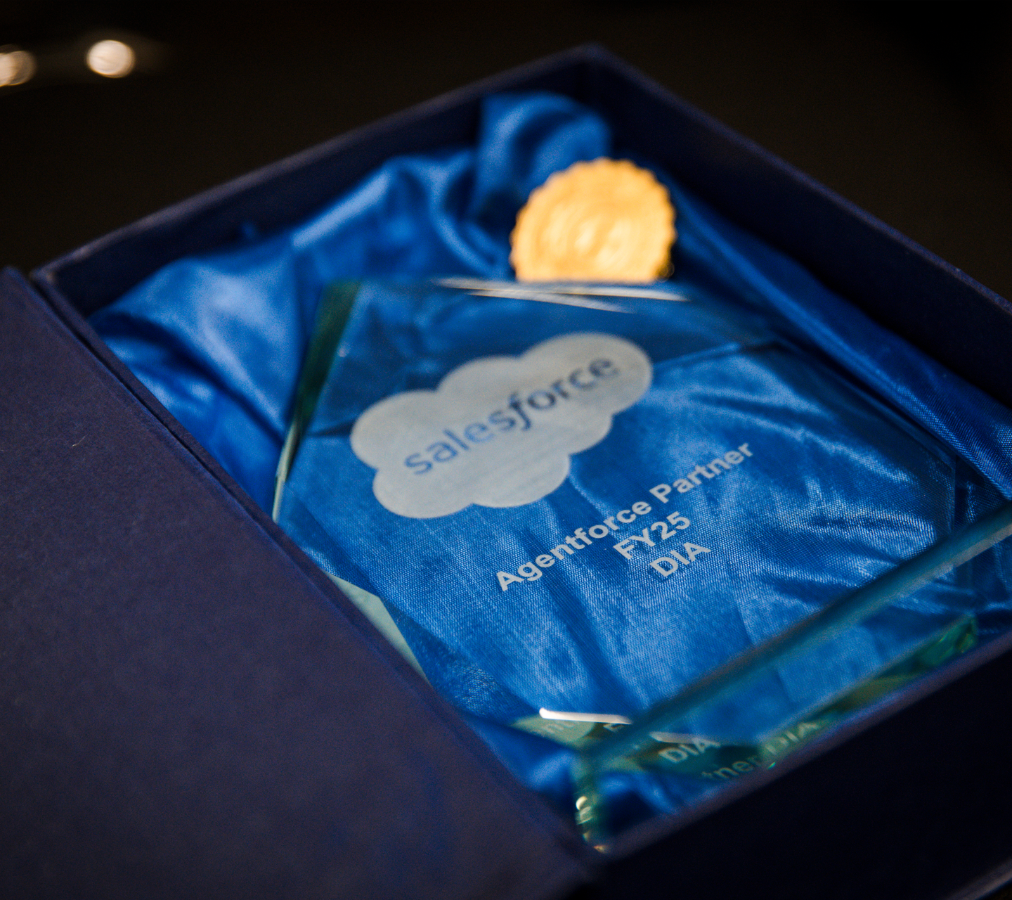 Salesforce Agentforce Partner FY25 DIA award plaque in a blue fabric-lined box.