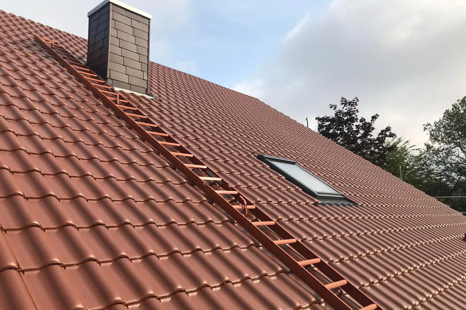 Rote Tondachziegel auf einer frisch eingedeckten Dachfläche