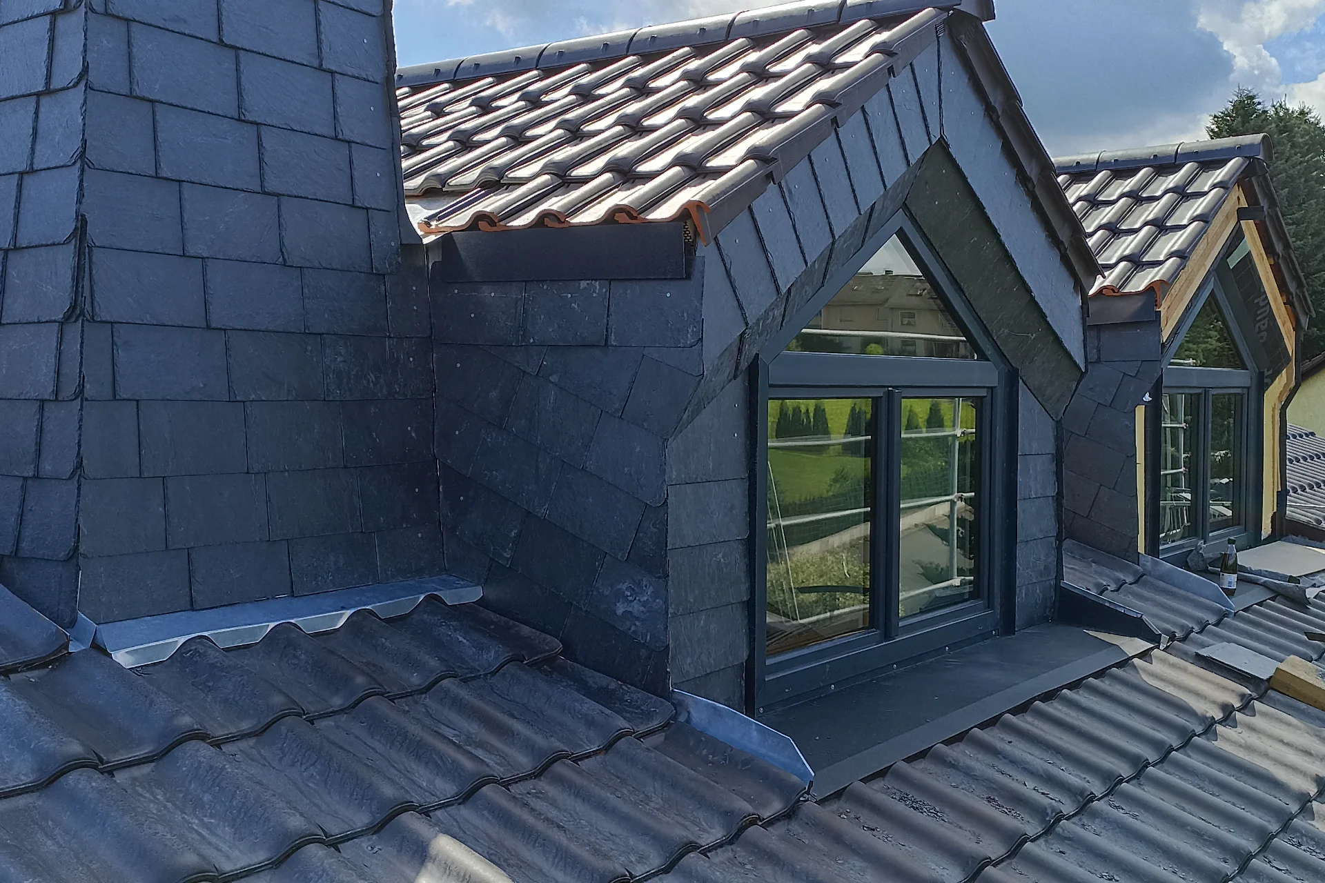 Verschieferte Fassade mit sauber eingefasstem Fenster