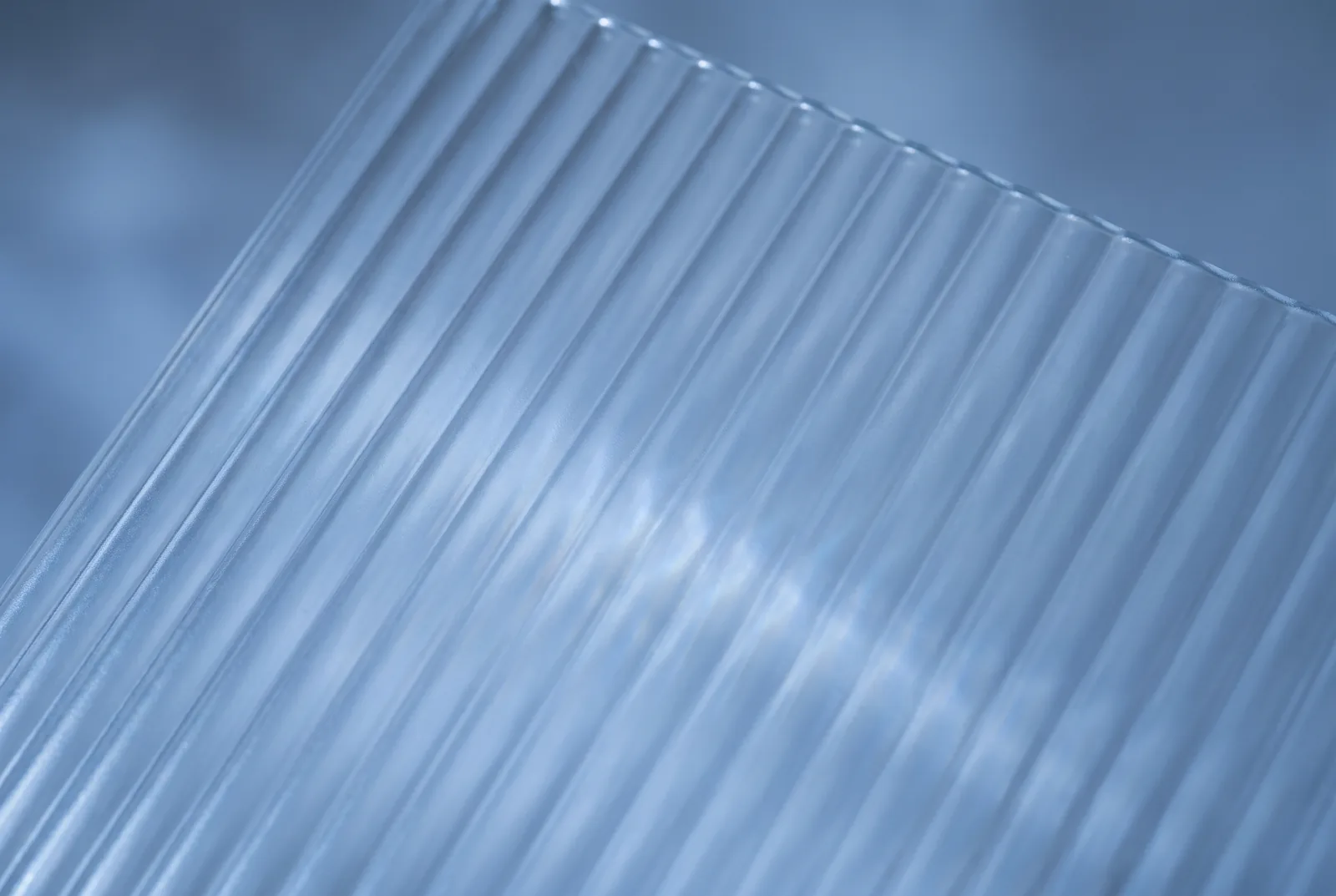 A corrugated translucent sheet in pale blue, ridges running diagonally, New Beach journal