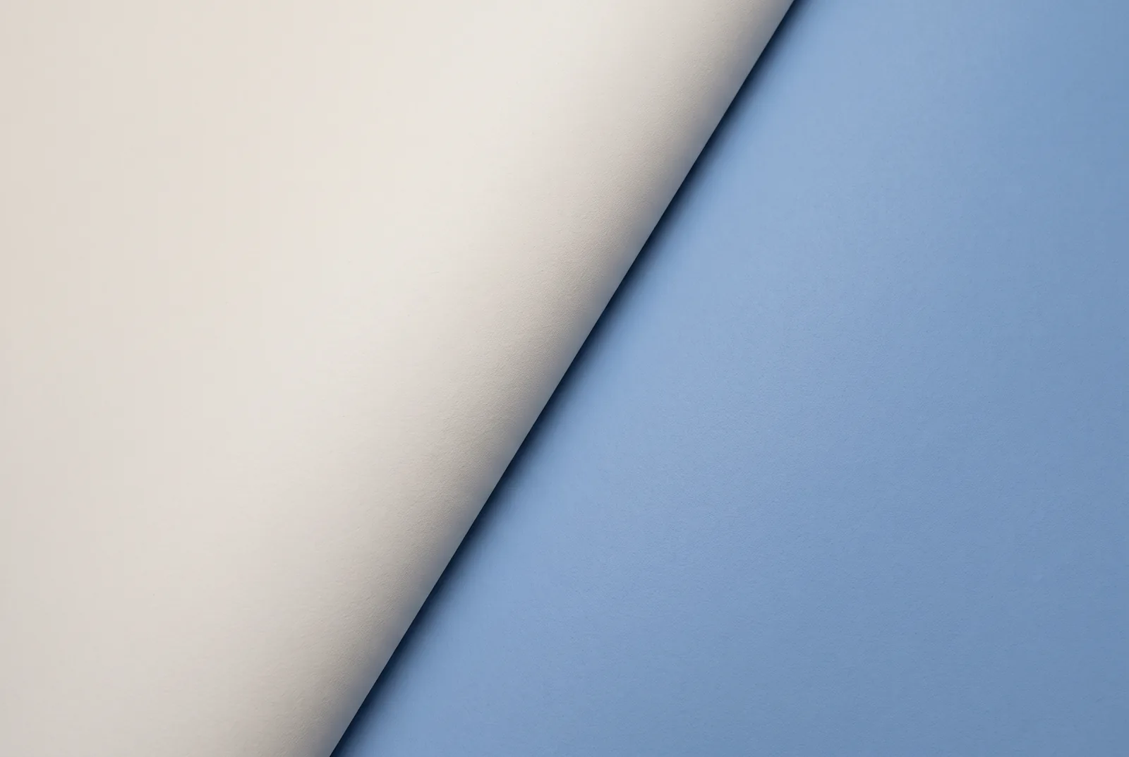 Two sheets of card, cream and pale blue, meeting along a sharp diagonal edge, New Beach journal