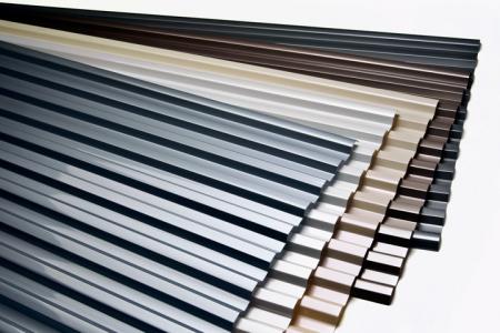 Stack of corrugated polycarbonate roofing sheets viewed end-on, showing the sheet profile