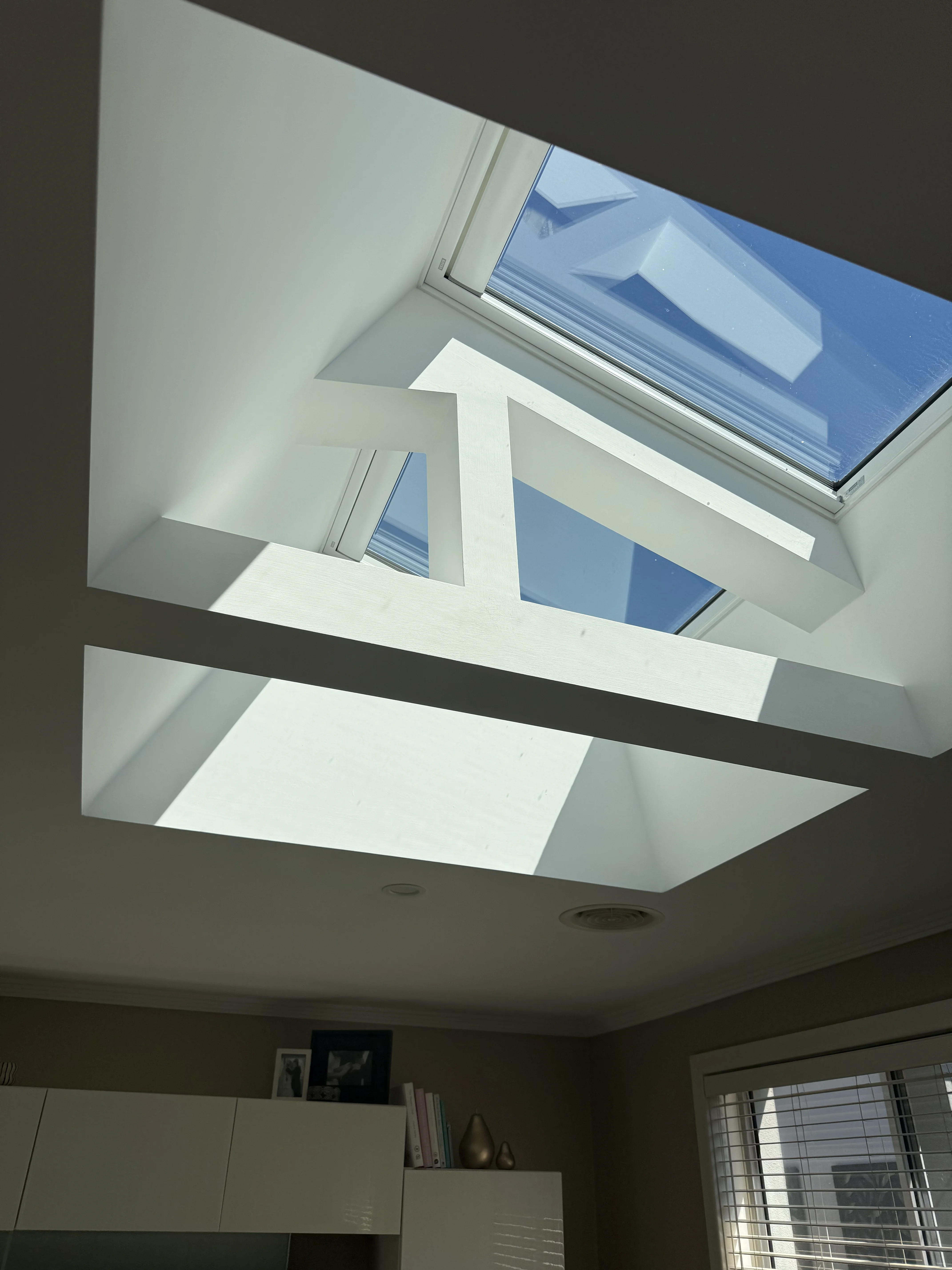 VELUX skylight with a blind fitted into a plastered ceiling shaft in a living room