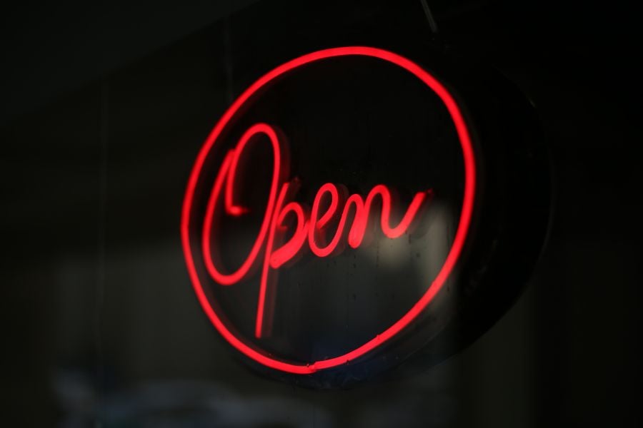 Glowing red neon Open script sign — example of Rick Signs neon sign repair and restoration in Chicago