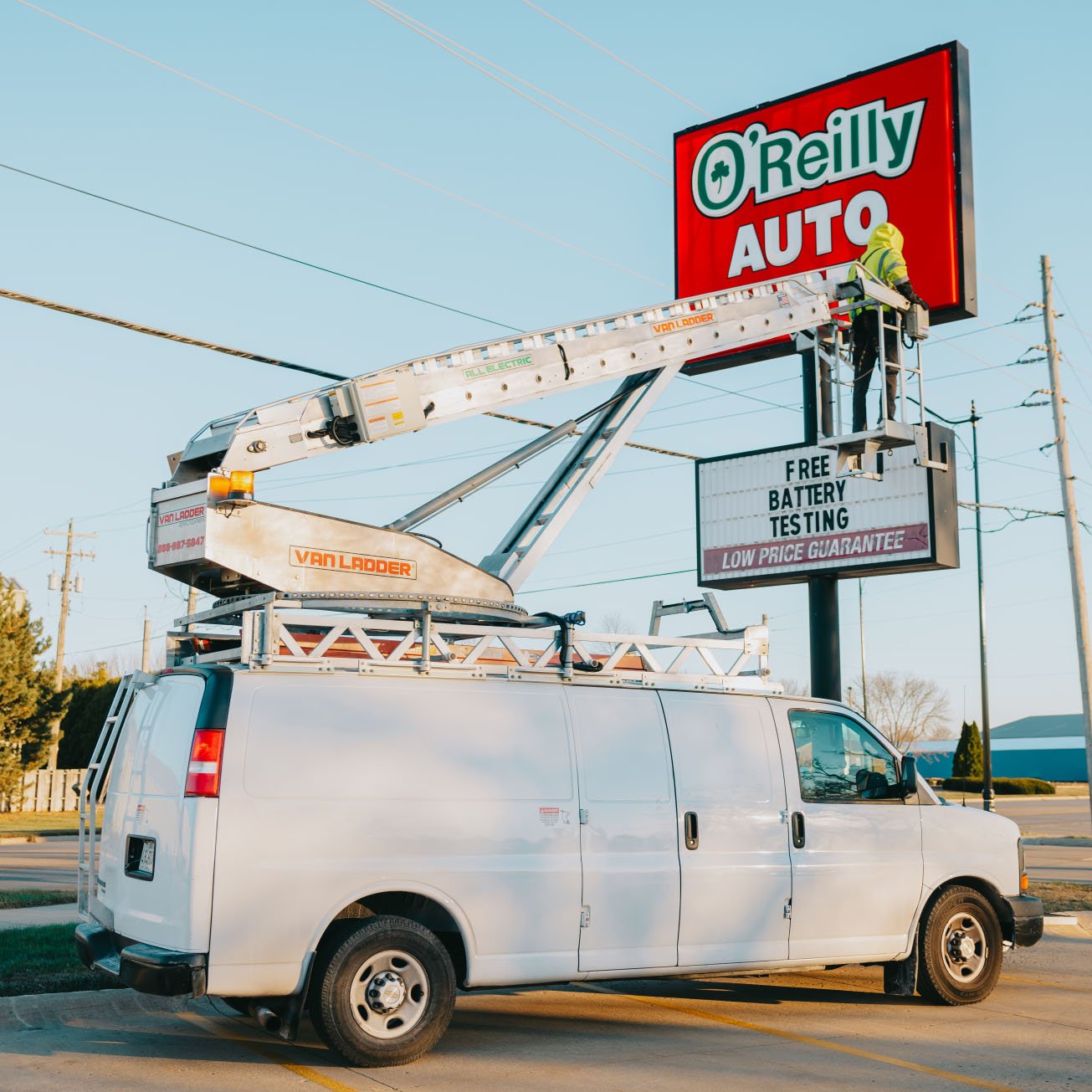 Rick Signs service van and bucket truck on site at an O’Reilly Auto Parts location during a Chicago sign service call