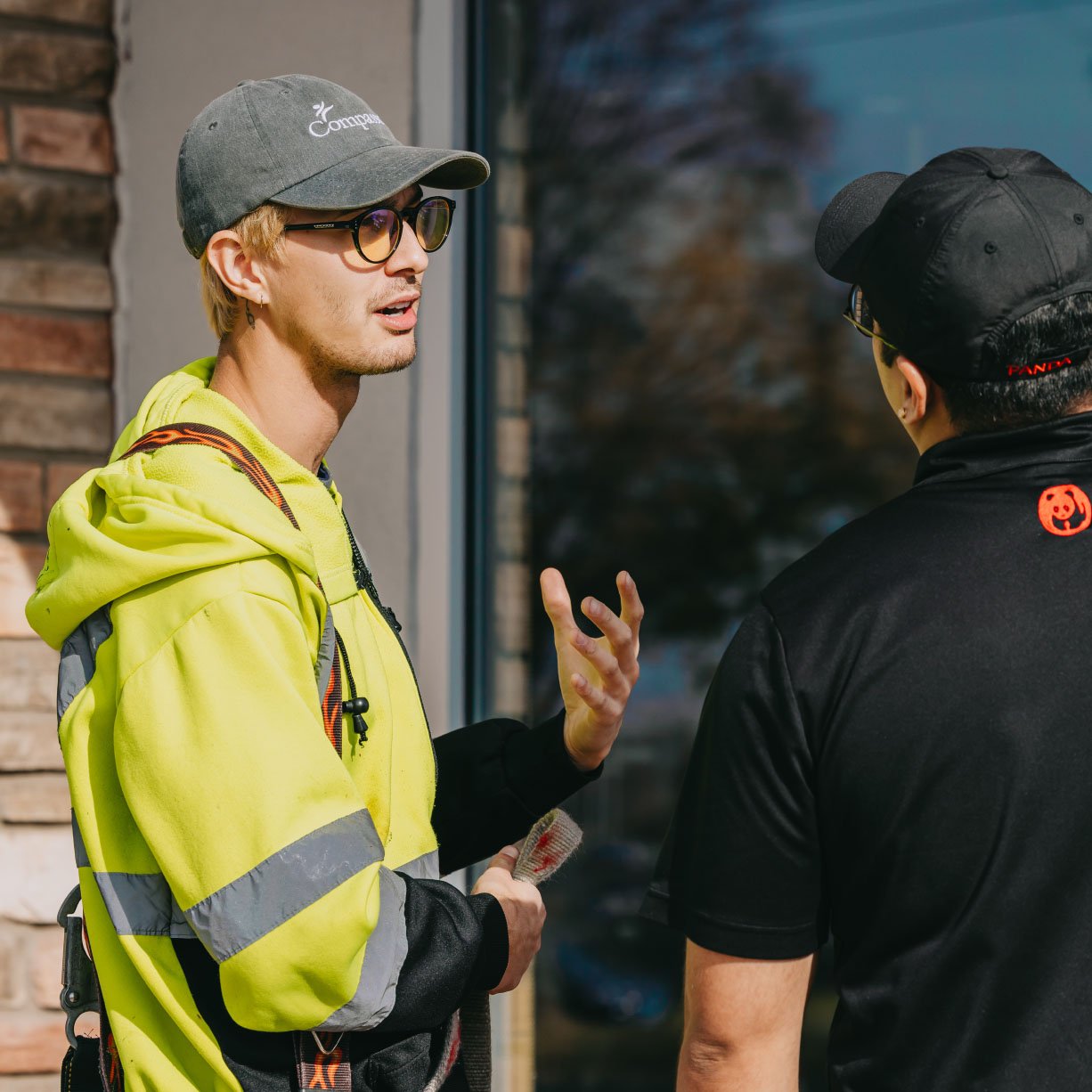 Two Rick Signs technicians conducting an on-site consultation outside a Chicago commercial storefront