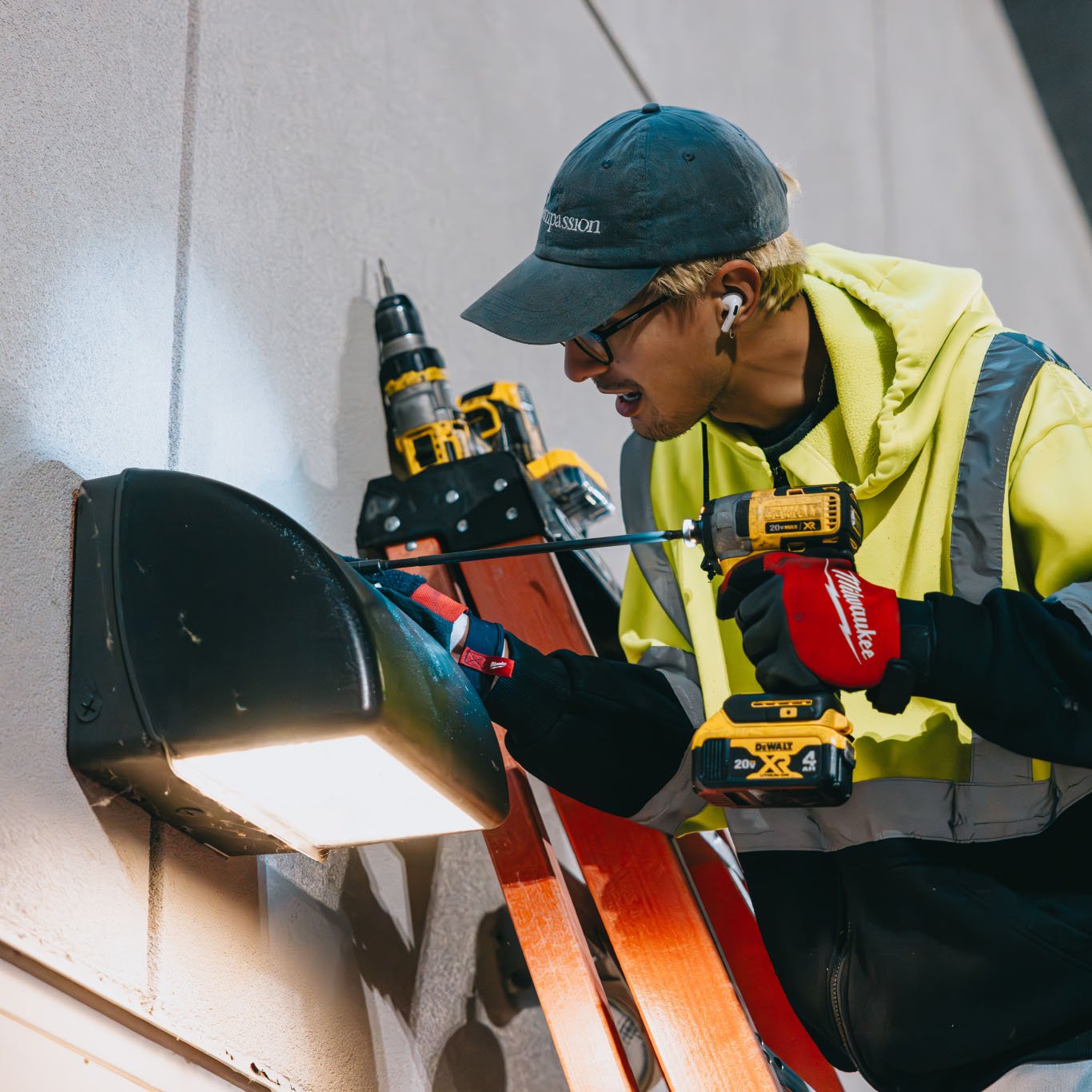 Tymothy Mough installing a black framed sign on a white wall in Chicago — Rick Signs custom sign install