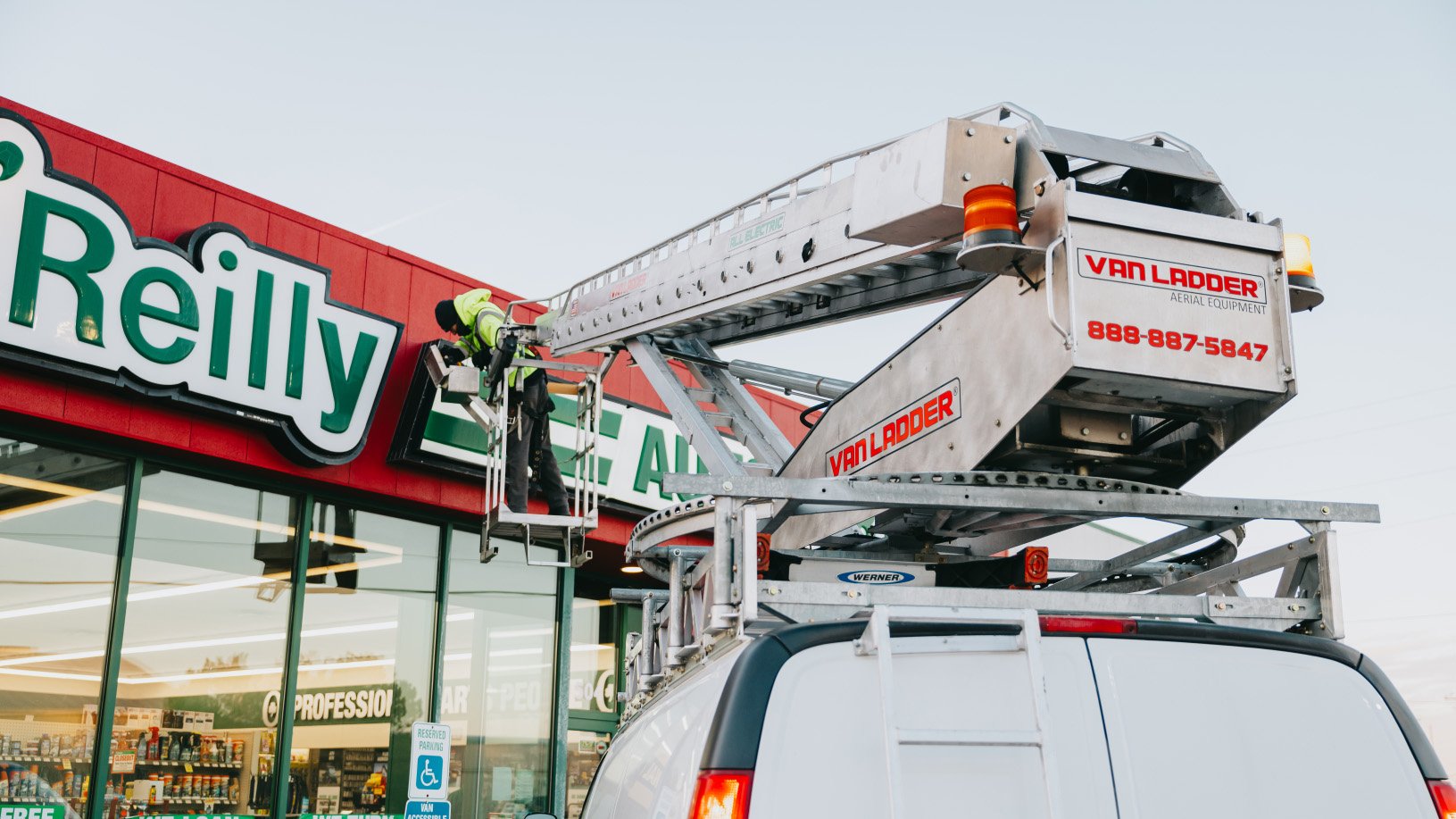 Close-up of the O’Reilly Auto Parts cabinet sign with the Rick Signs Van Ladder bucket truck in frame — Chicago