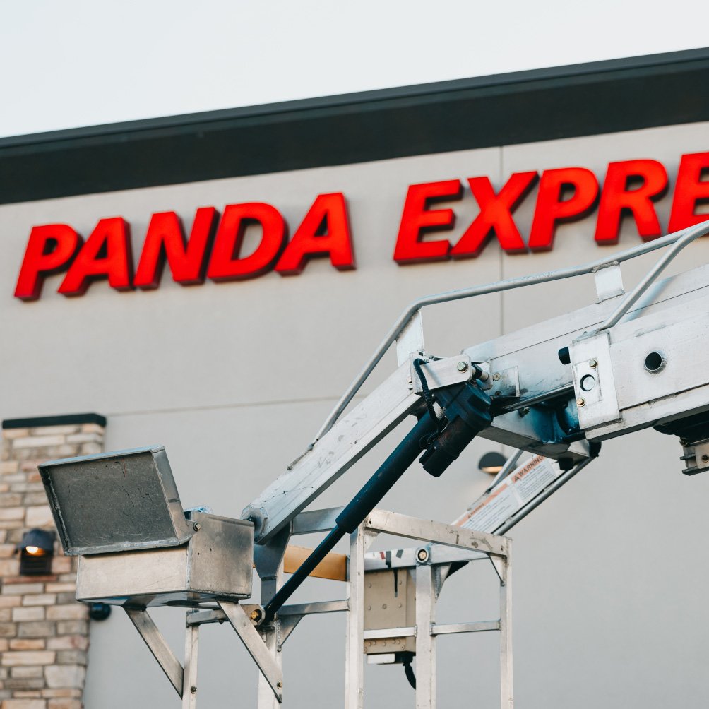 Tymothy Mough installing LED modules in the Panda Express EXPRESS channel letters from the bucket truck — Rick Signs Chicago