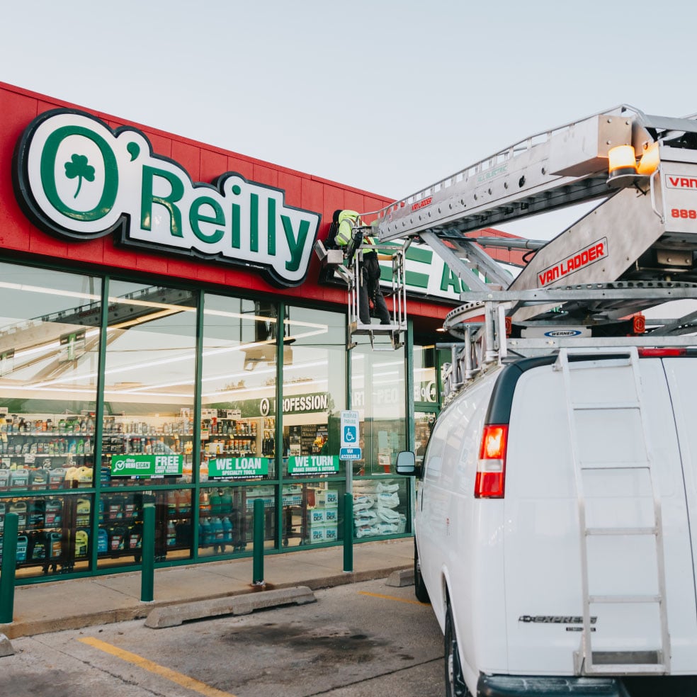 Rick Signs bucket truck servicing the illuminated O’Reilly Auto Parts storefront sign in Chicago