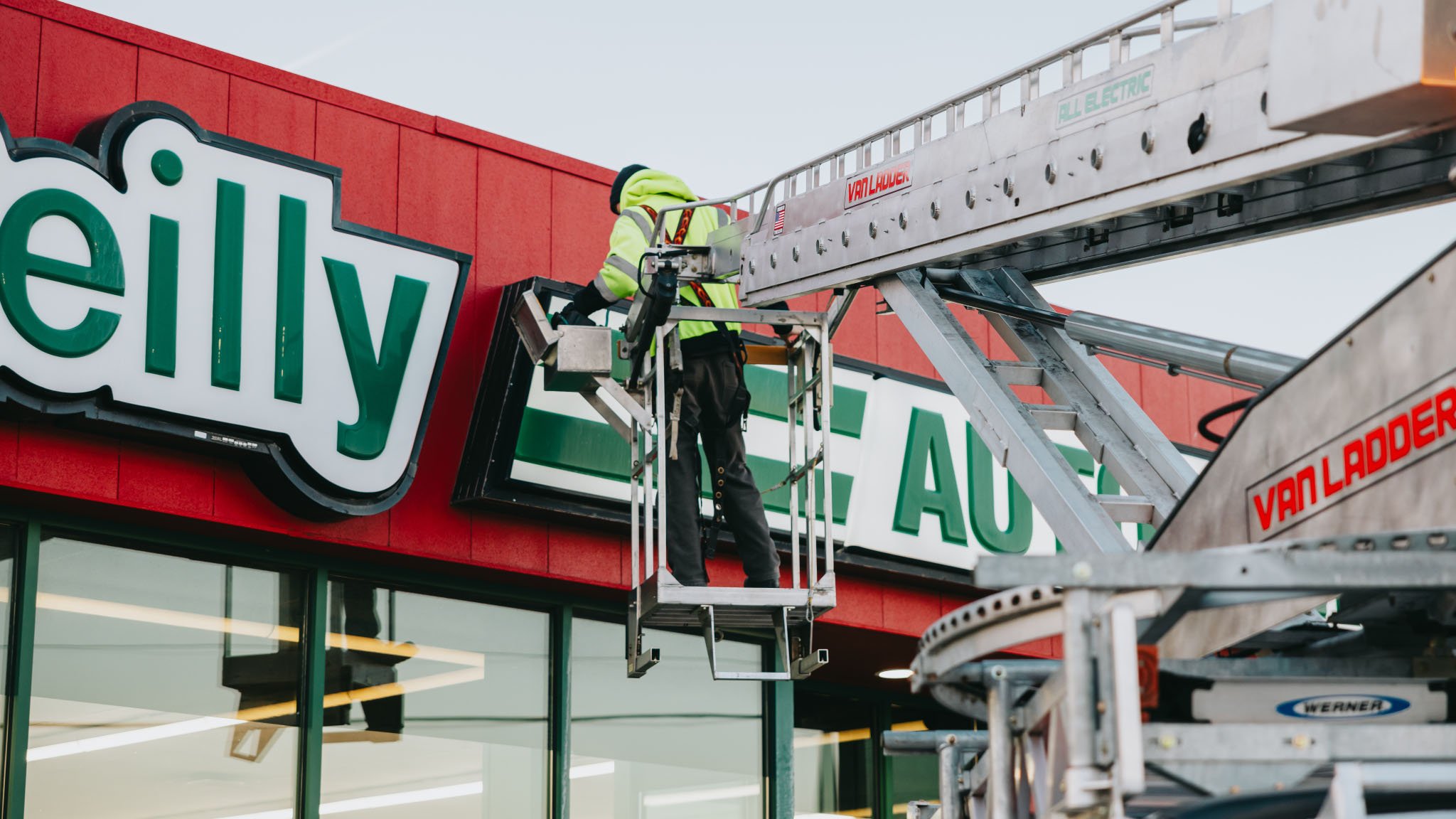 Rick Signs technician repairing the O’Reilly Auto Parts channel letter sign from a Van Ladder bucket truck in Chicago
