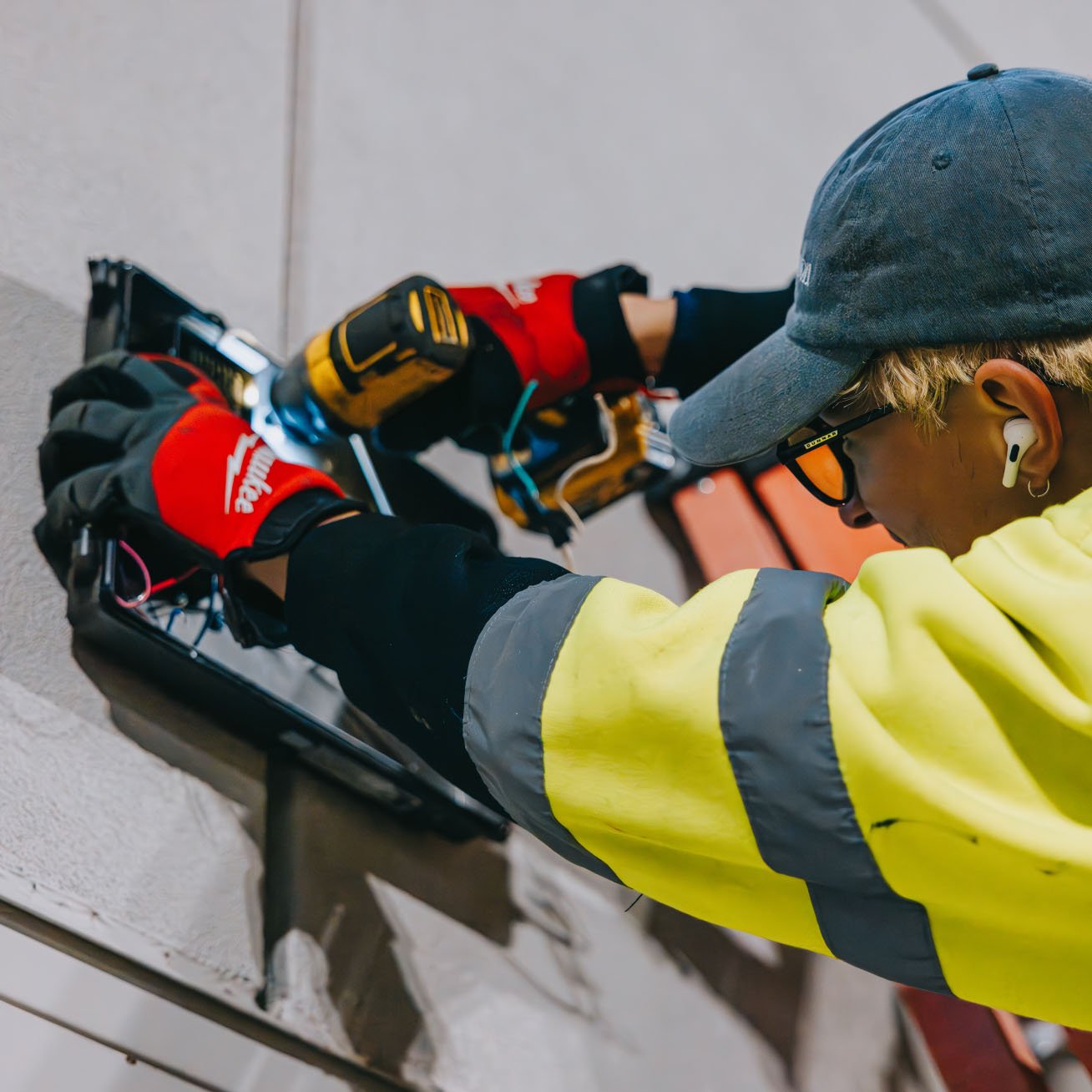 Cordless drill and hands working on the electrical components inside a channel letter sign — Rick Signs Chicago repair