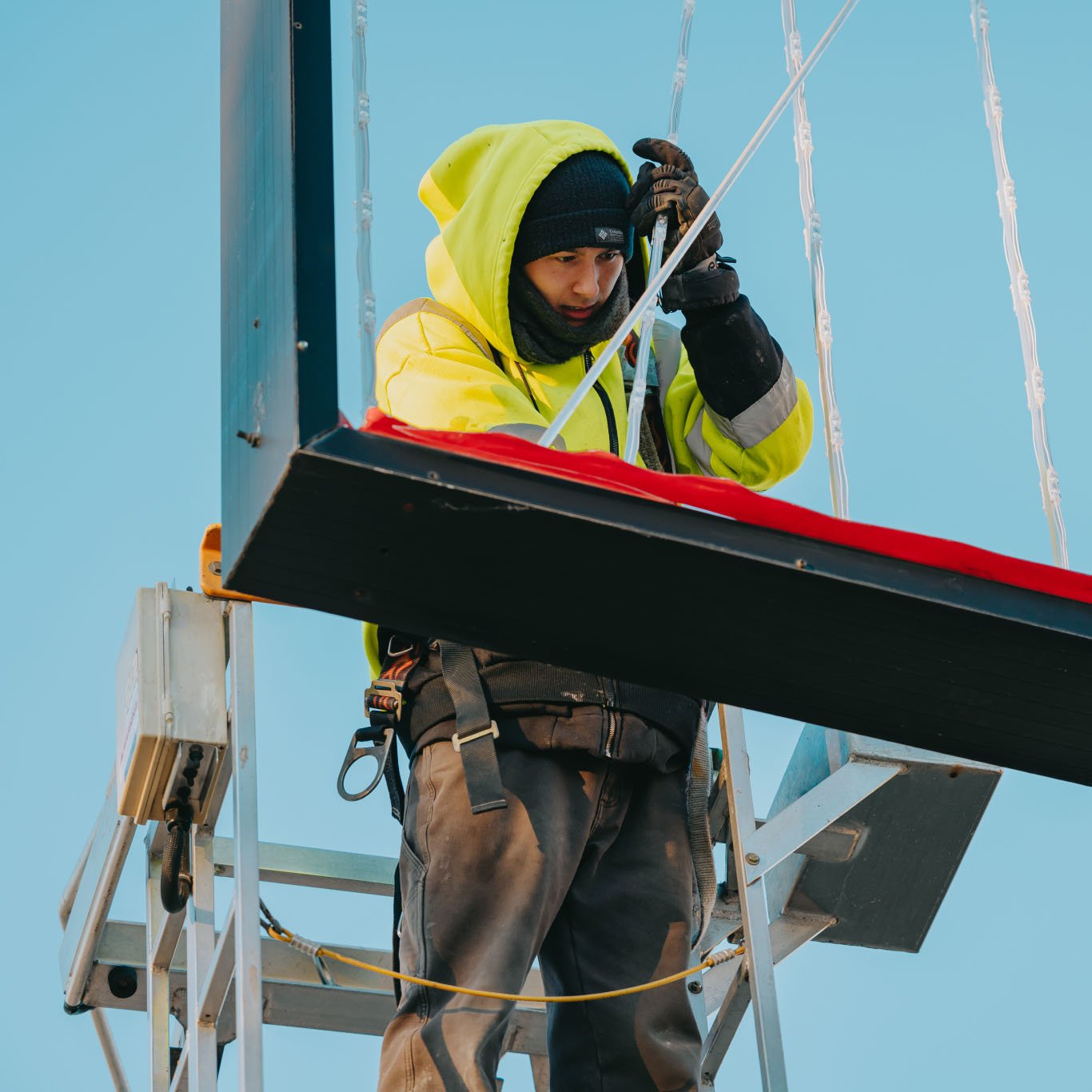 Rick Signs technician operating the bucket truck during a winter pole sign service call in Chicago