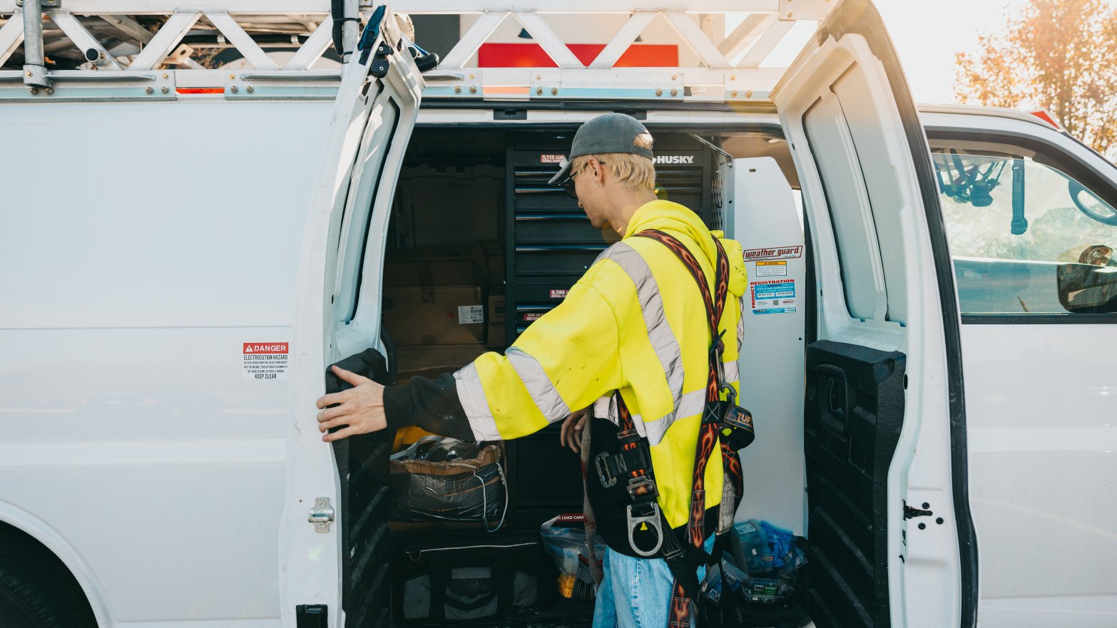 Rick Signs technician loading equipment from the service van at a Chicago sign repair job
