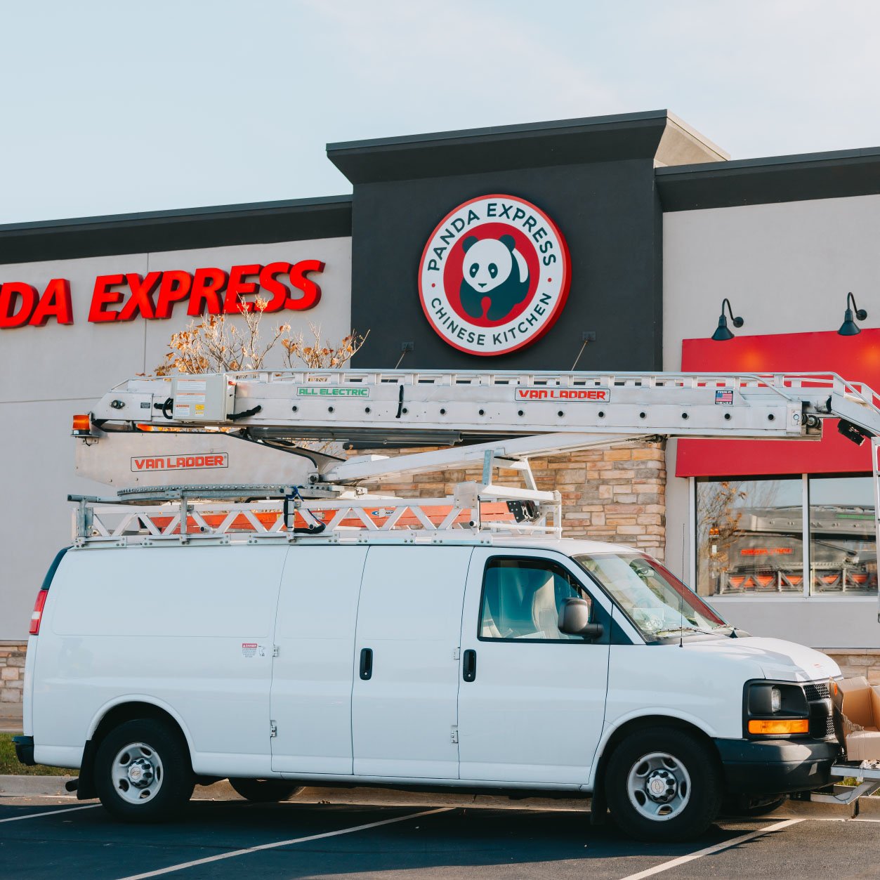 Rick Signs service van with bucket truck on site at a Panda Express location in Chicago