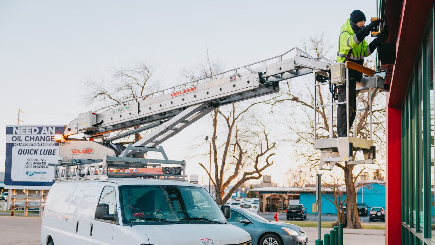 Rick Signs bucket truck servicing a Panda Express channel letter storefront sign in Chicago