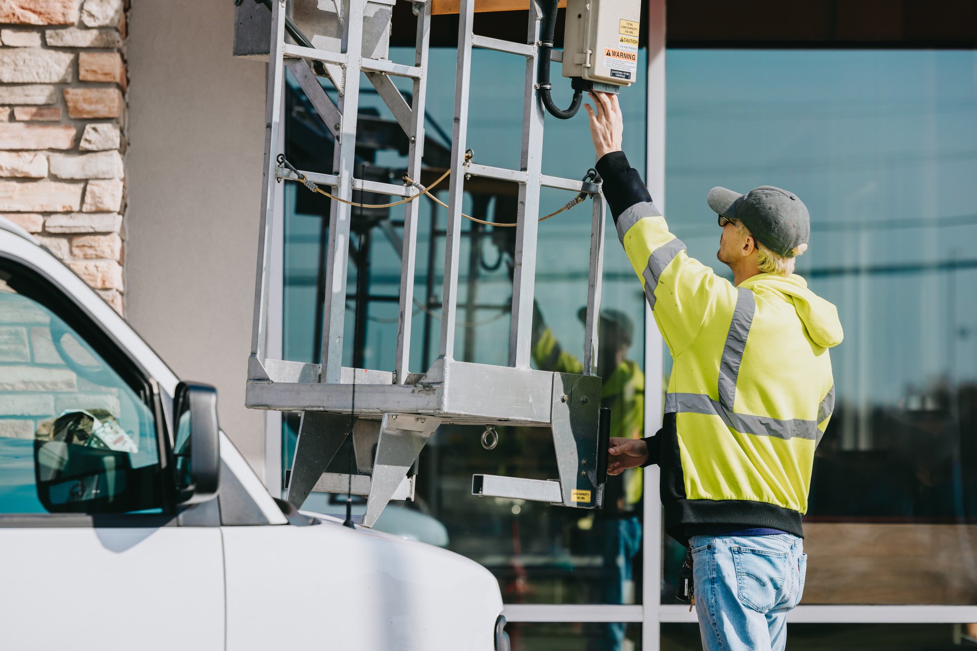 Tymothy Mough operating the Van Ladder bucket truck lift outside a commercial storefront during a Rick Signs sign service call in Chicago