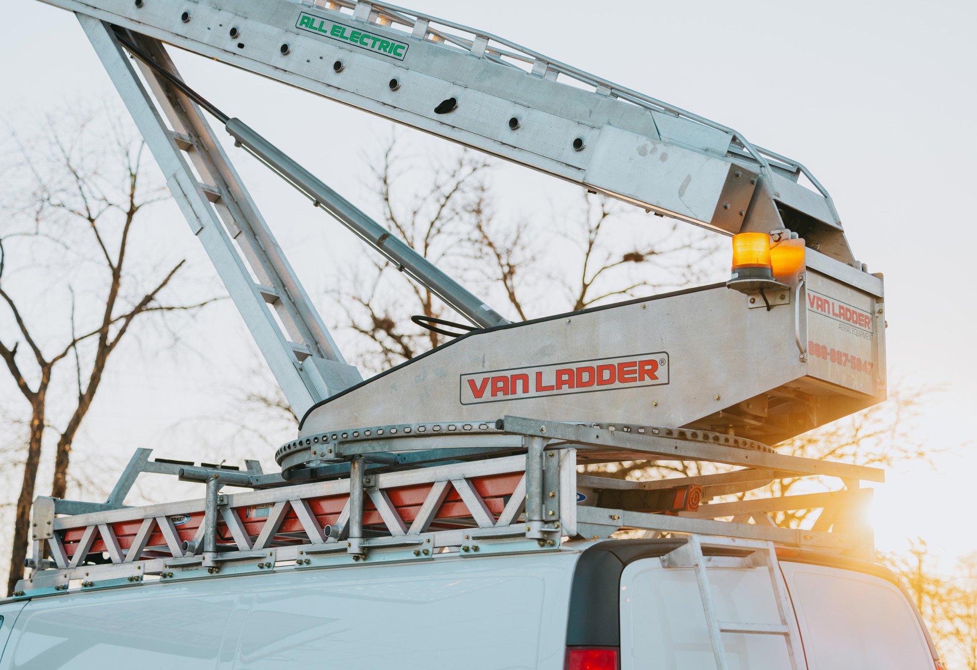 Rick Signs & Repairs Van Ladder aerial bucket truck parked at sunset — Chicago sign repair fleet
