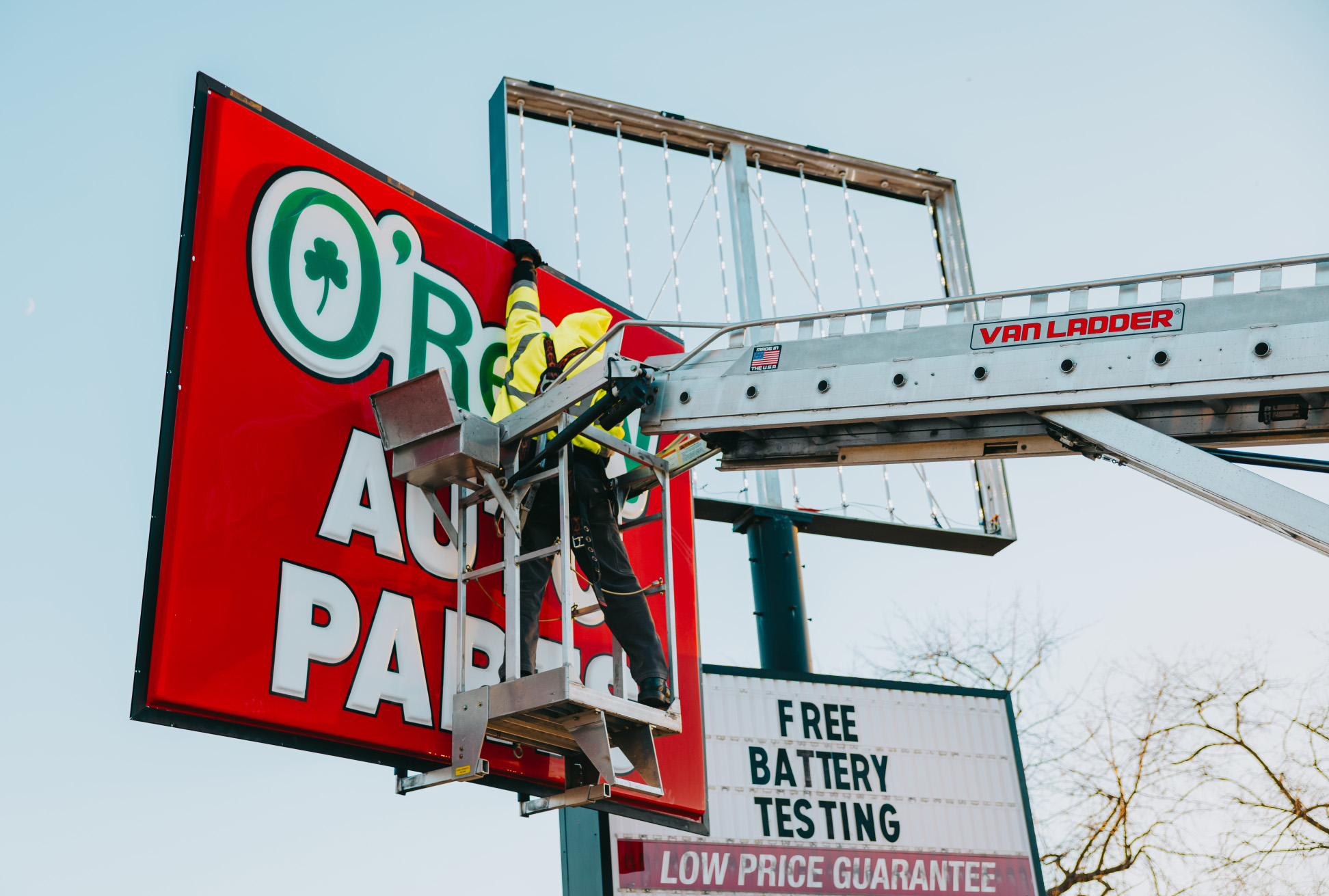 Tymothy Mough of Rick Signs & Repairs in a Van Ladder bucket truck repairing the O’Reilly Auto Parts illuminated pole sign in Chicago
