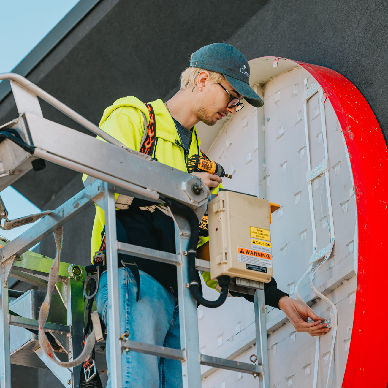 Tymothy Mough of Rick Signs & Repairs installing LED modules inside a channel letter sign on a bucket truck lift