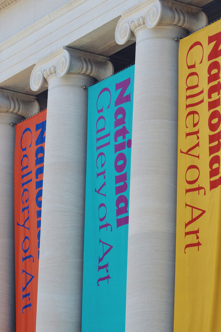 Three colored banners reading National Gallery of Art hang between classical columns.