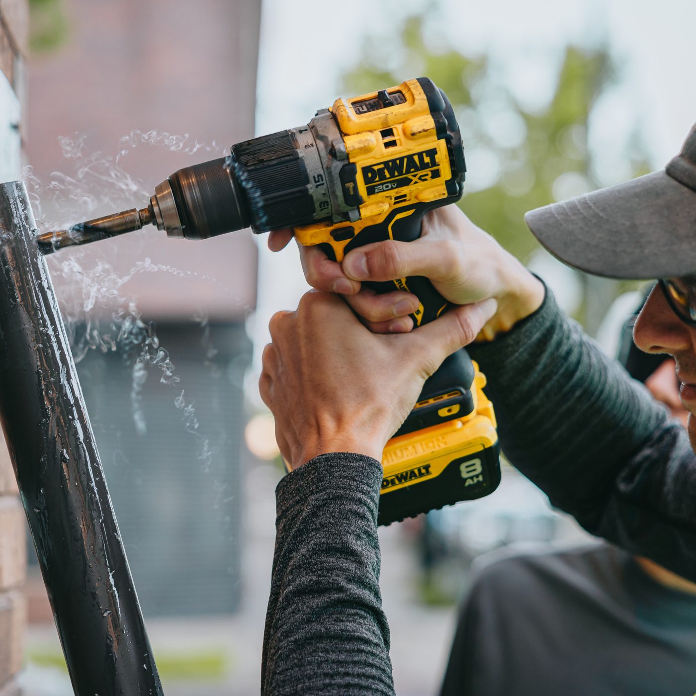 Hammer drill boring an anchor hole for a projecting sign bracket during a Rick Signs installation in Chicago
