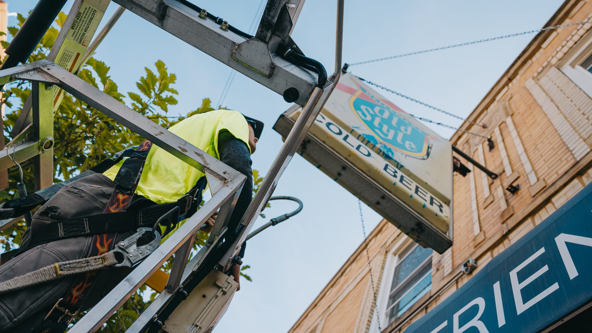 Rick Signs technician working from the bucket truck beside the Old Style sign at Empty Bottle, Chicago