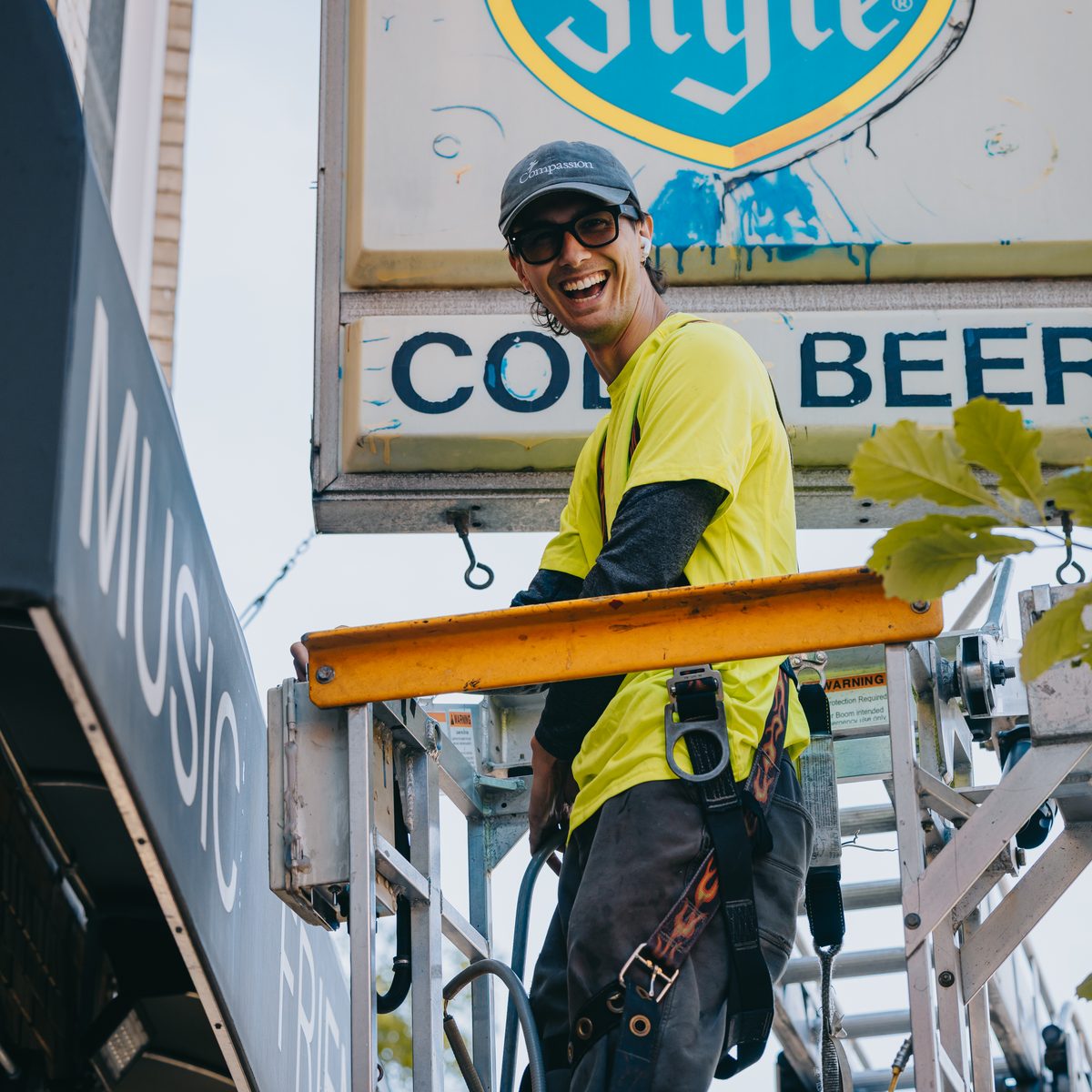 Rick Signs technician on the lift beneath the installed Old Style Cold Beer sign on North Western Avenue, Chicago