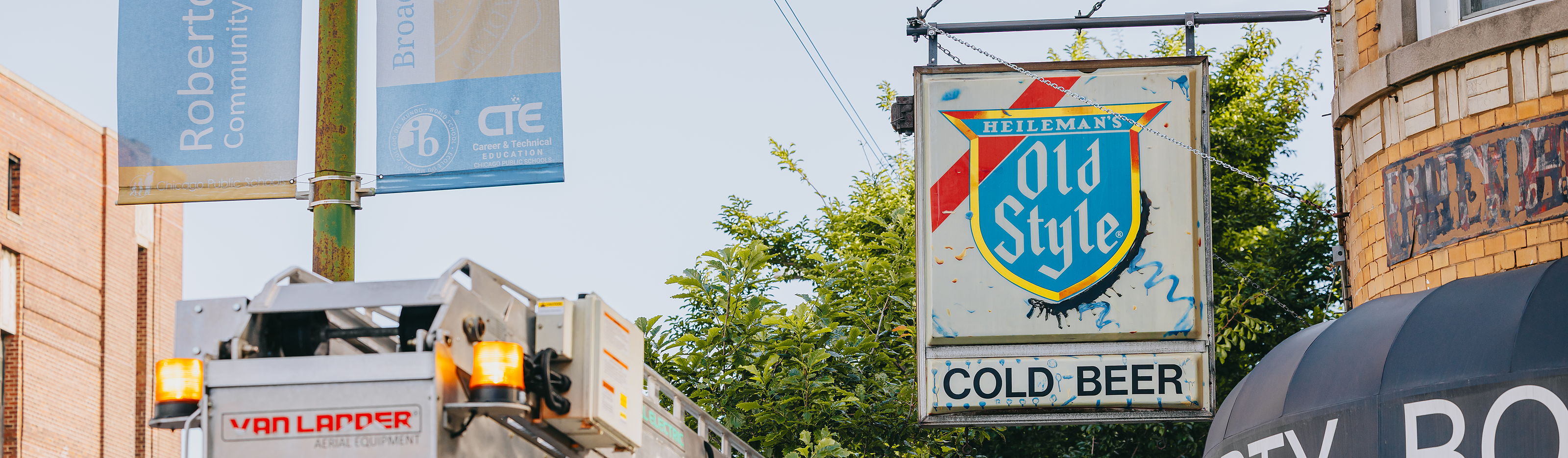 Vintage Heileman's Old Style COLD BEER projecting sign hanging outside the Empty Bottle in Ukrainian Village, Chicago, with the Rick Signs Van Ladder bucket truck staged below