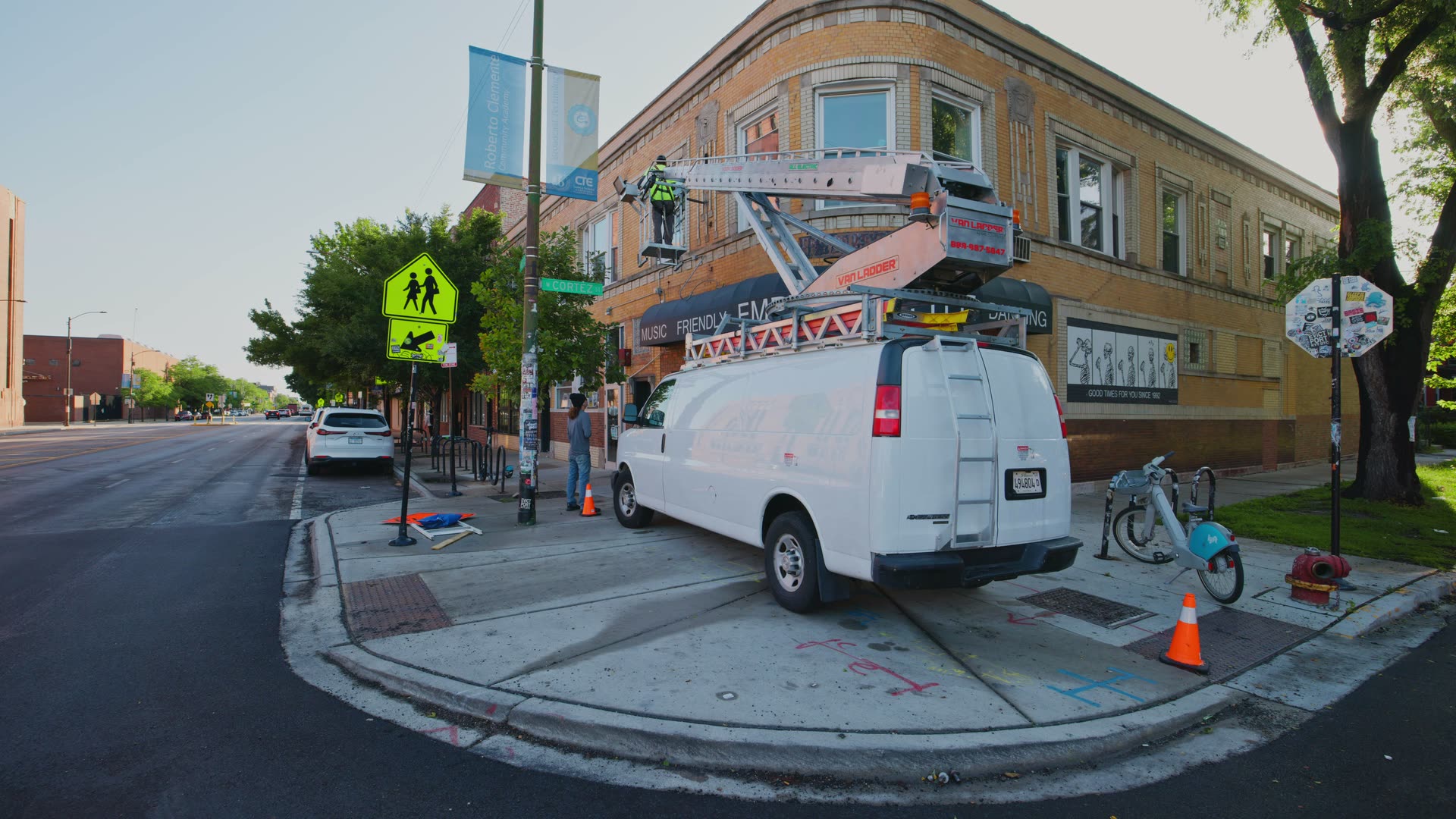 Rick Signs & Repairs van and Van Ladder bucket truck working the corner of North Western Avenue and West Cortez Street outside the Empty Bottle in Chicago