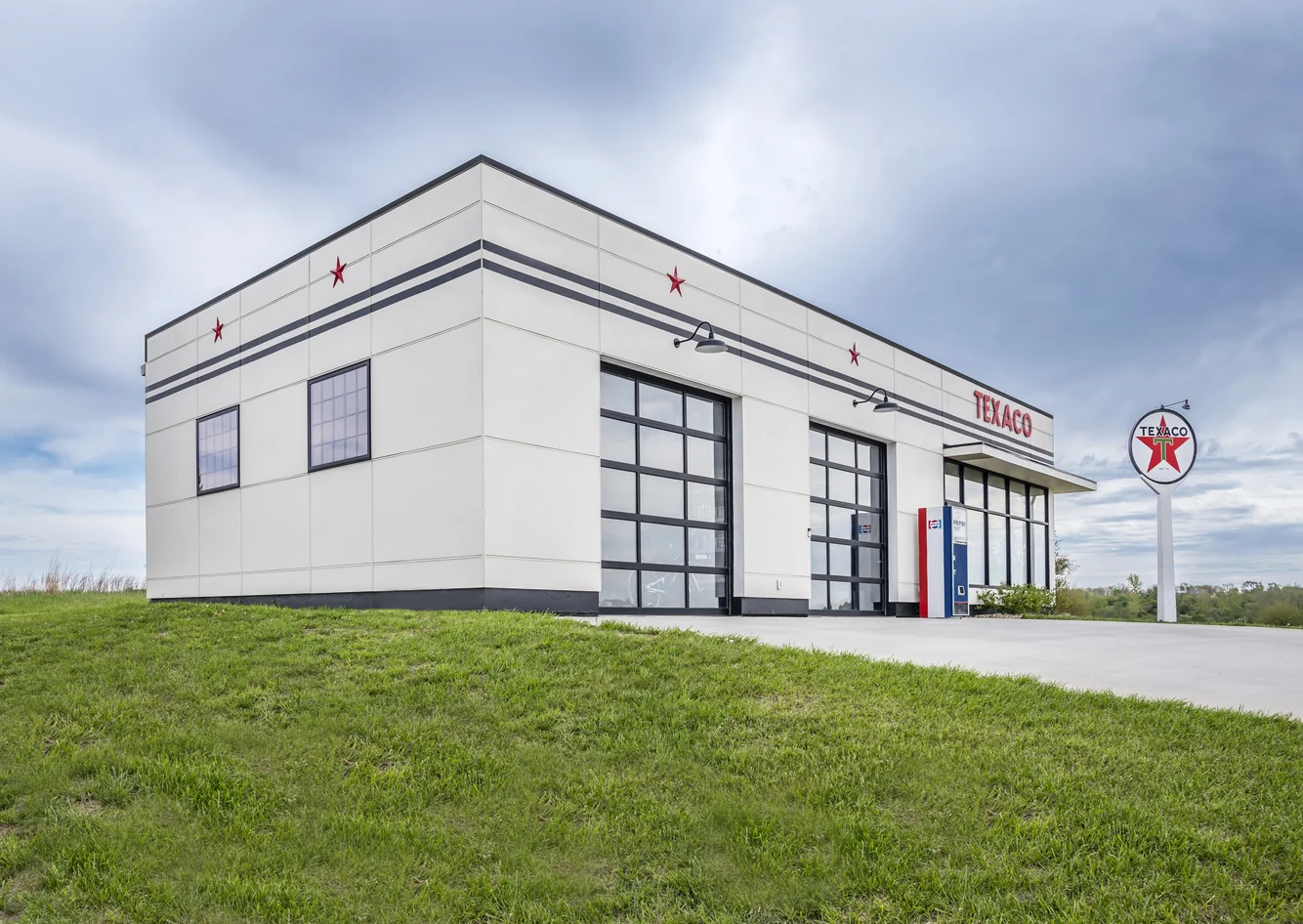 Texaco-themed garage exterior with glass bay doors at the Scott Hill Texaco project