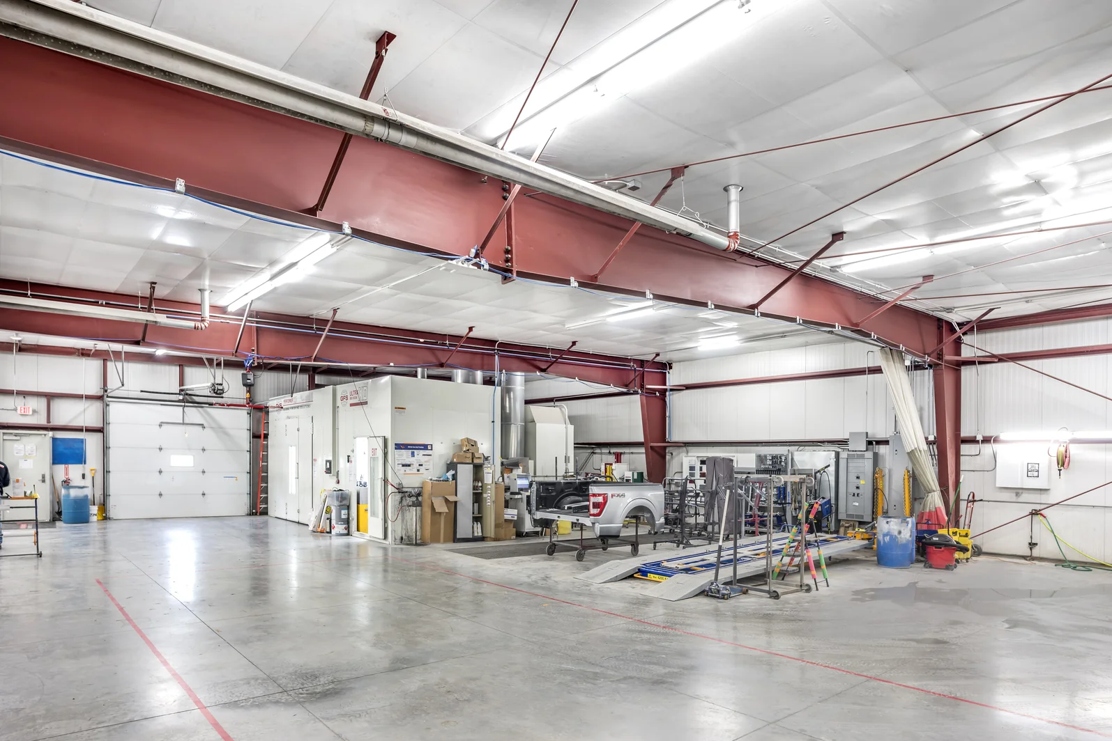 Paint booth and frame rack equipment inside the Crash Champions collision repair building