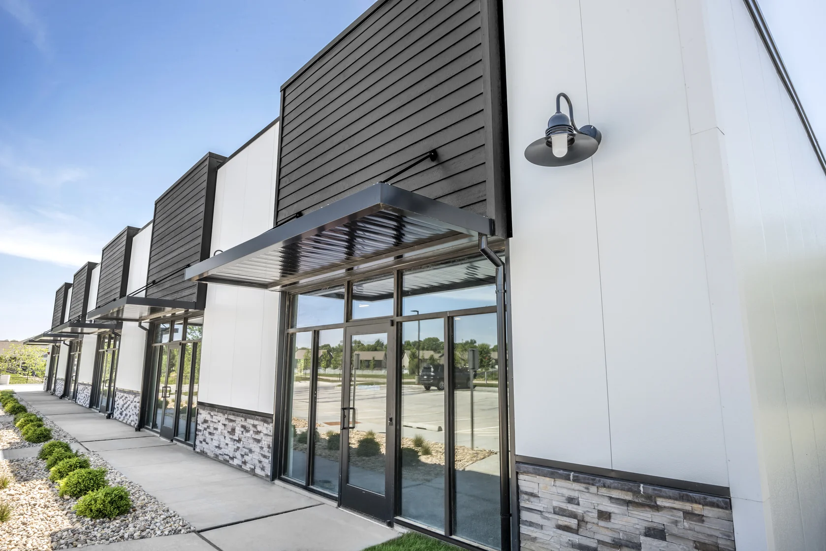 Storefront entrance canopy with stone base detail at the I-Mark project