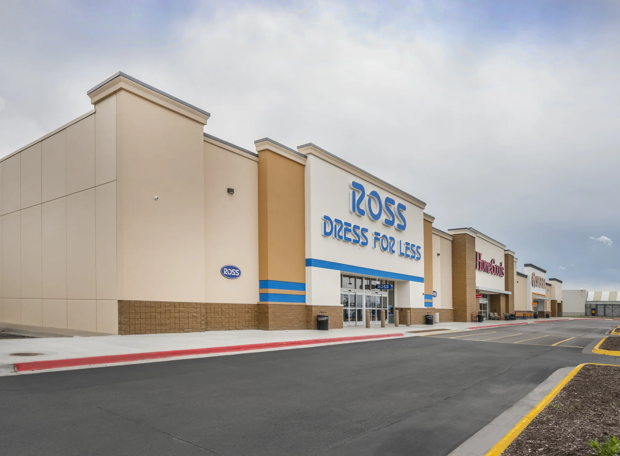 Ross Dress For Less retail plaza with large blue signage and adjacent stores along the parking lot.