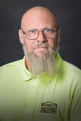 Headshot of a Midwest Erectors crew member with a long gray and white beard and glasses, wearing a neon yellow-green company polo, additional photo
