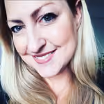 Porträt einer lächelnden Frau mit langen blonden Haaren und blauen Augen.