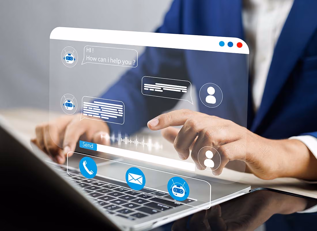 Person tippt auf Laptop mit virtueller Chatbot- und Kommunikationsschnittstelle.