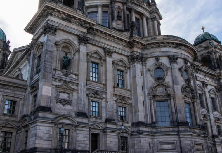 Fassade des Berliner Doms mit Fenstern und barockem Architekturdetail unter bewölktem Himmel.
