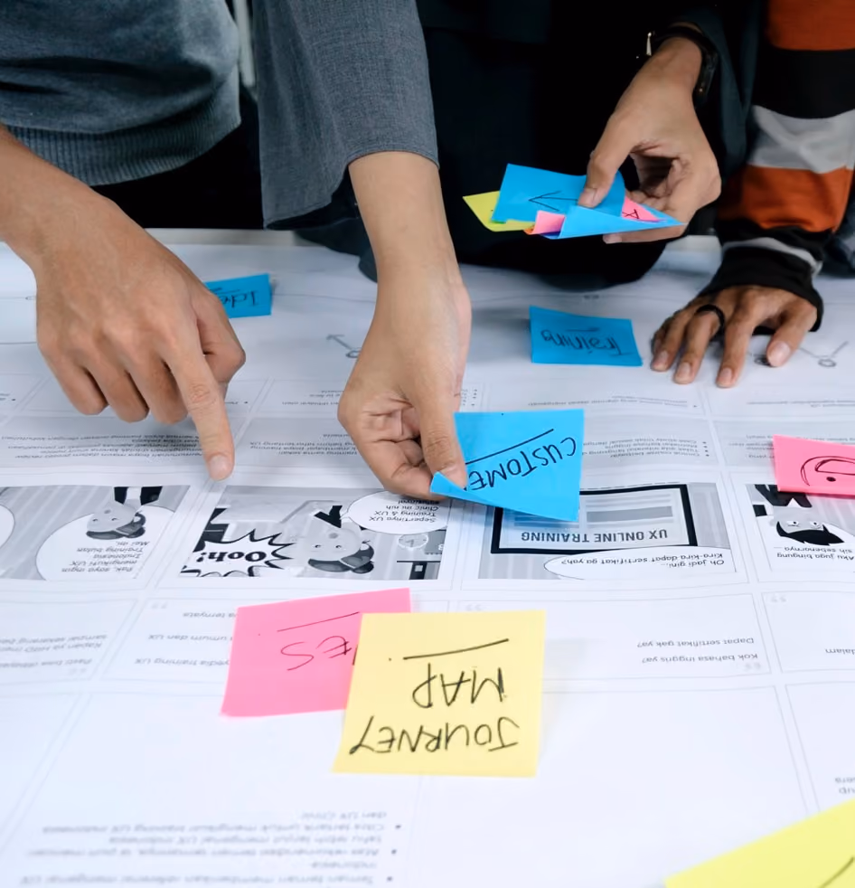 Team arbeitet mit Post-its und Wireframes an der Planung einer digitalen Anwendung.