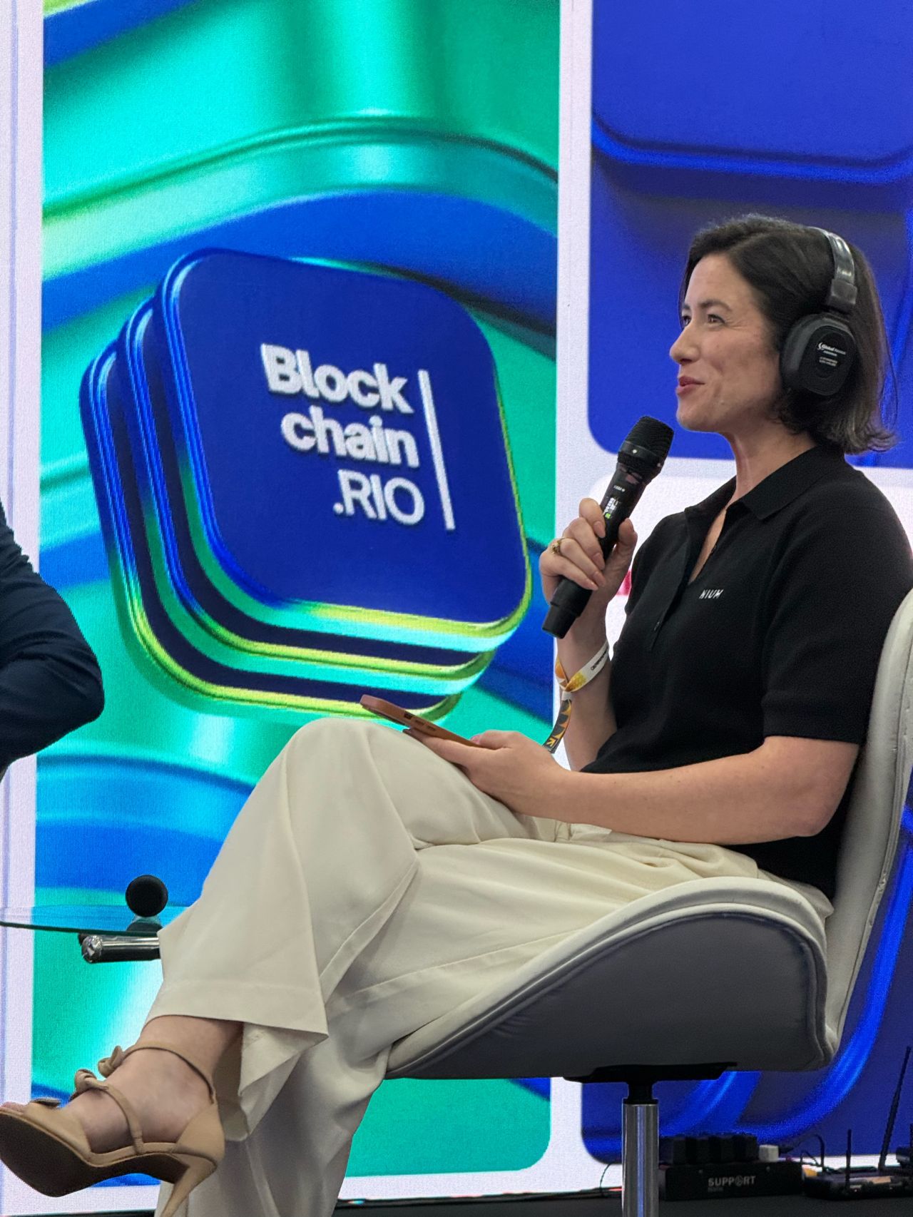 Lia Thomazzi Susin, VP of Account Management, Americas, on stage at Blockchain.RIO in August 2026.