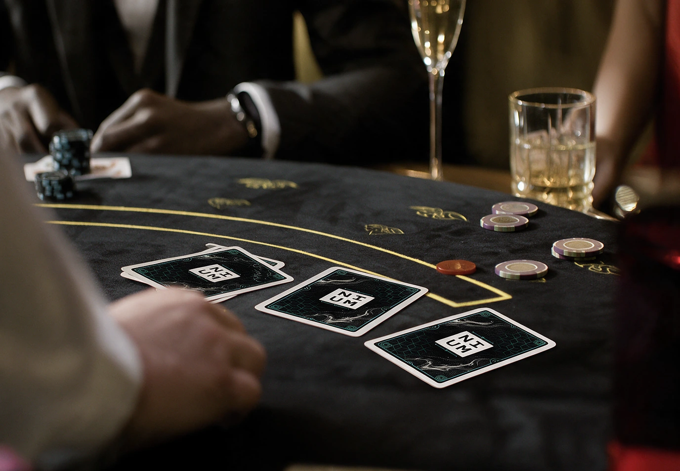 Blackjack table with Nium-branded playing cards, chips and cocktails