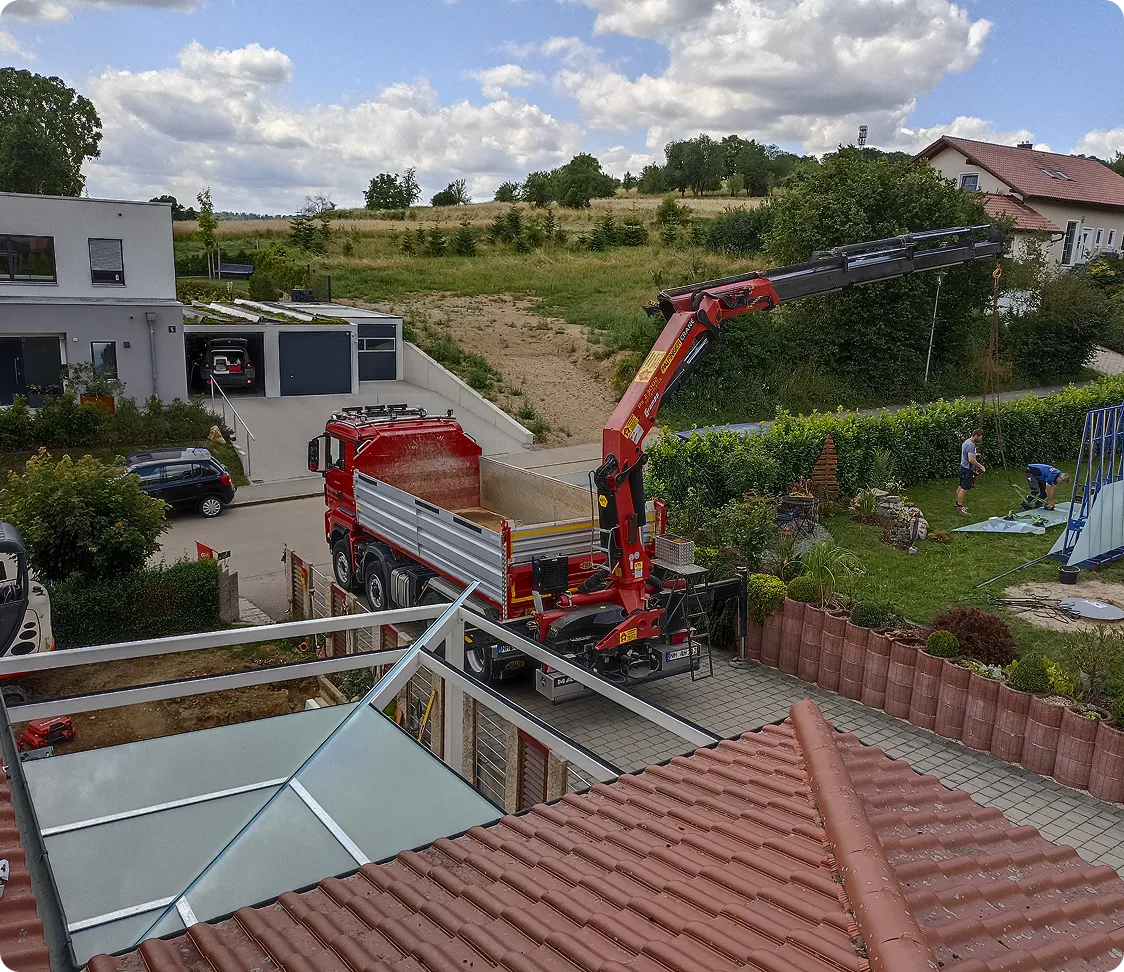 Ladekran-LKW bei der Montage einer Überdachung an einem Wohnhaus