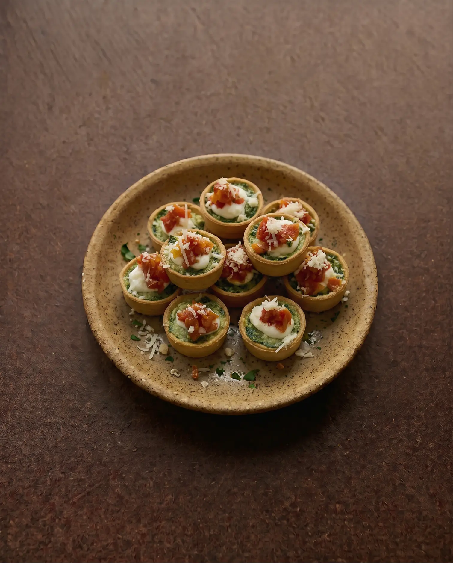 Elegant dish with caviar, herbs, and edible flowers arranged in a deep beige bowl on marble.