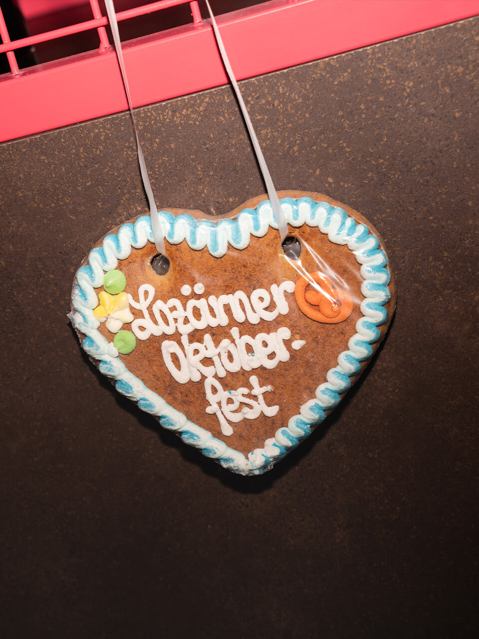 Herzförmiger Lebkuchenanhänger mit blau-weißer Verzierung und Text „Luzämer Oktoberfest“.