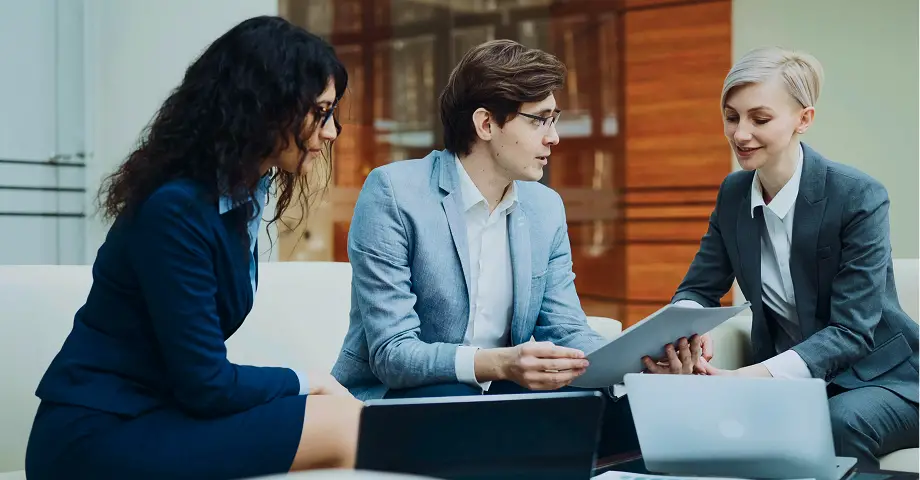 Two women and a men sitting down and talking.