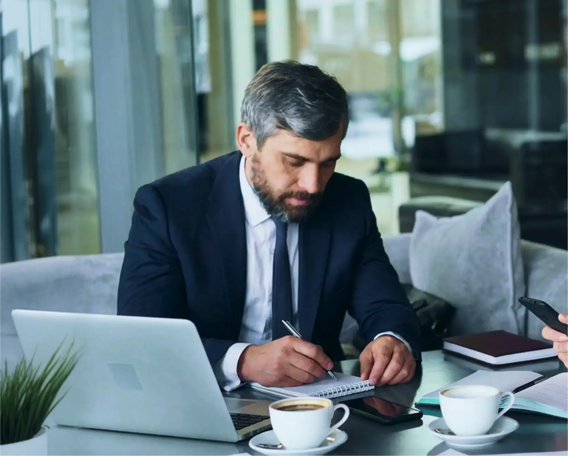 A man sitting down writing on a notepad.