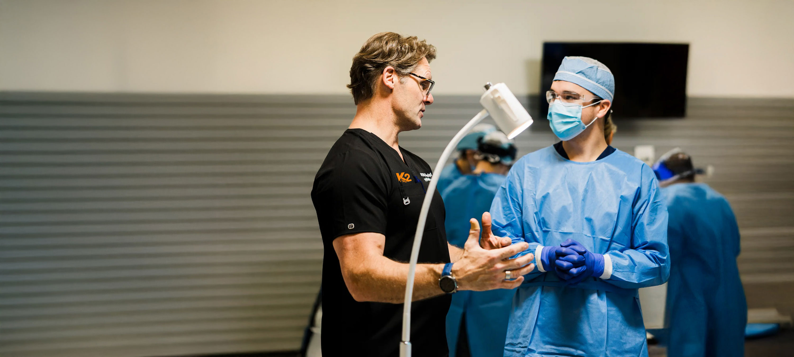 Dr. Rick Kapitan, founder, lead surgeon. and dental implant maxillofacial specialist, is engaged in conversation with another dental implant oral surgeon.