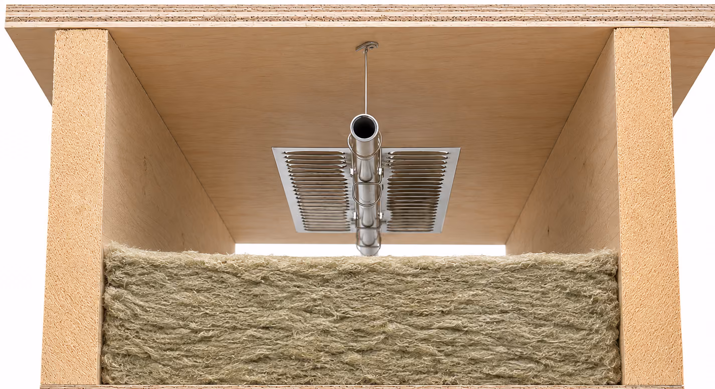 Interior view of a wooden box with a metal pipe and insulation material inside.
