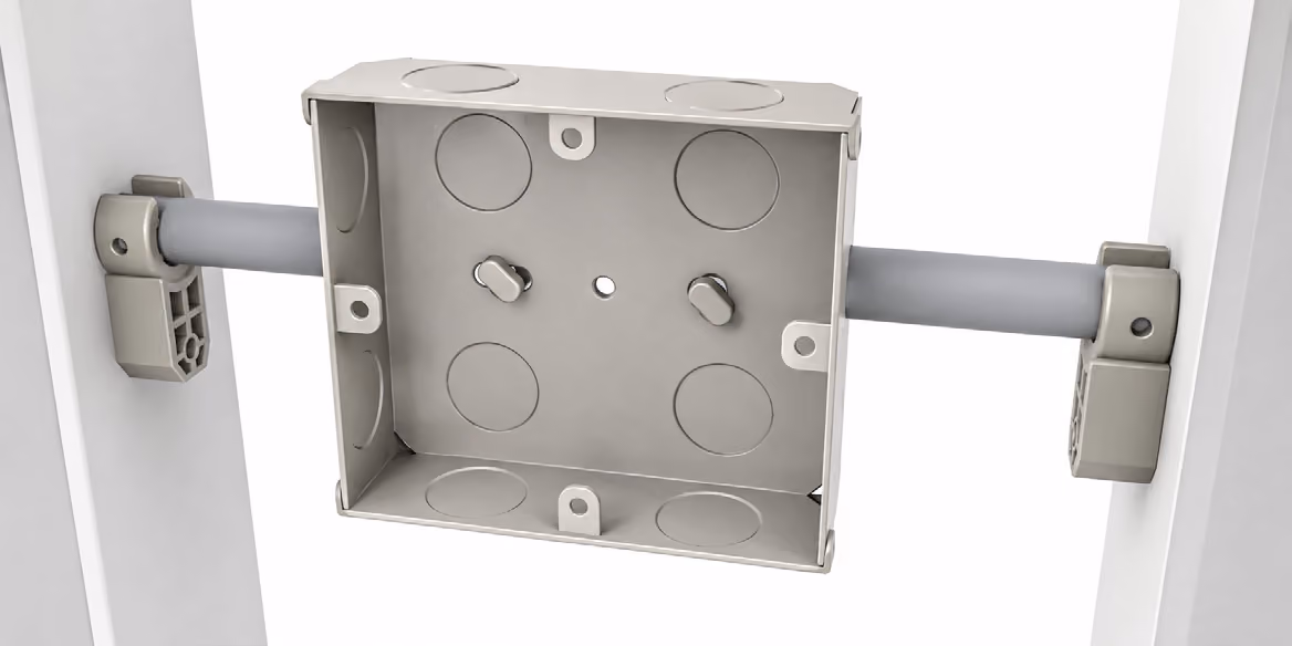Empty rectangular metal electrical junction box mounted between two white panels with gray conduit pipes.